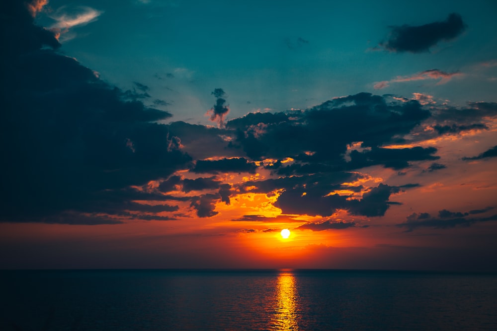 silhouette of person on body of water during sunset