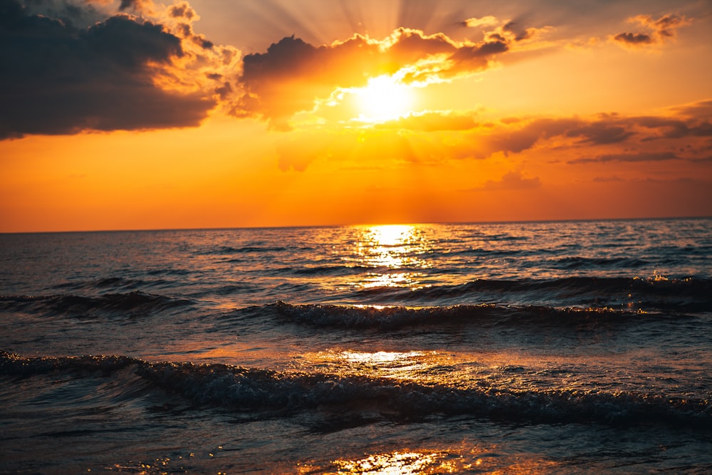 sea waves crashing on shore during sunset