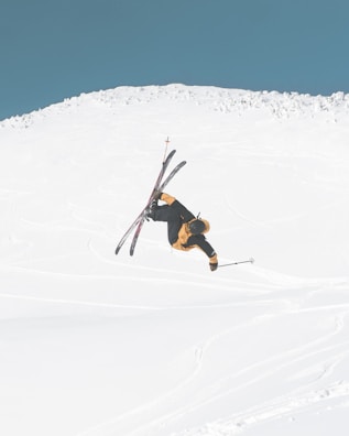 man in black jacket and brown pants doing snow ski during daytime