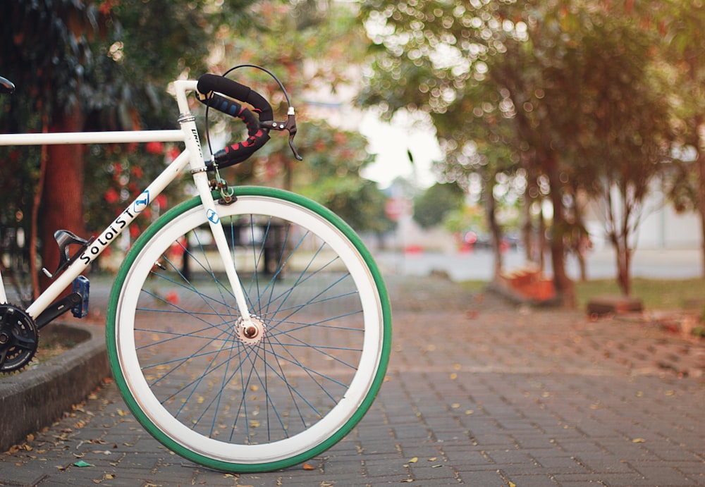 white and black city bike on brown brick floor during daytime