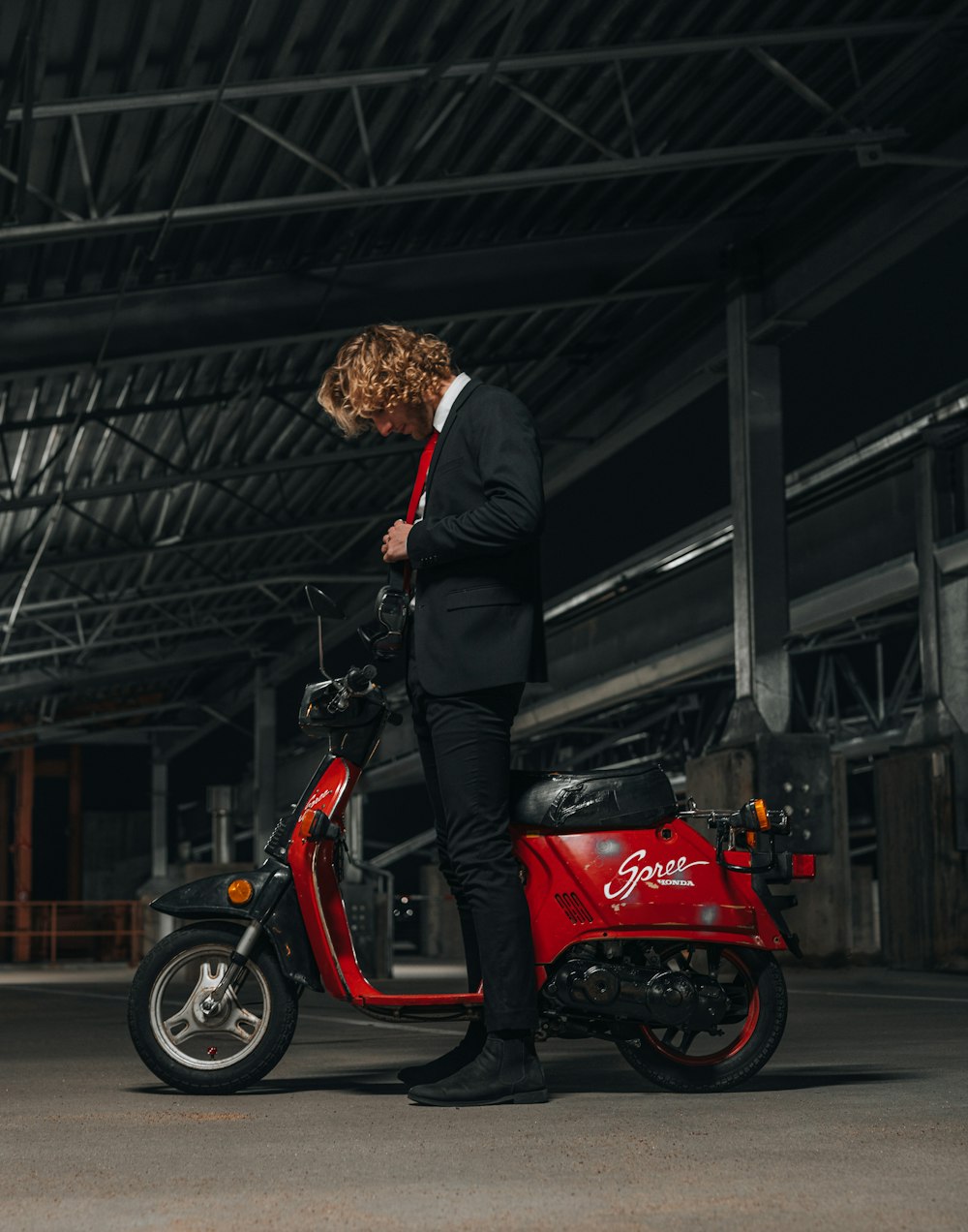 man in black jacket riding red motorcycle