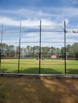 The Farming Baseball Team practicing on the community field under a bright sky.