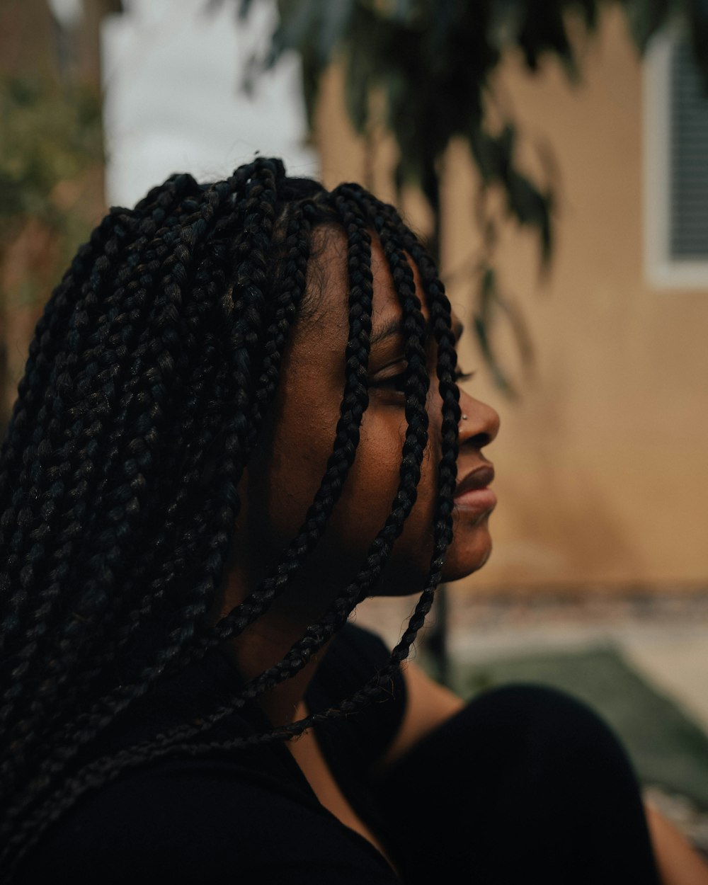 person with braided hair wearing black shirt