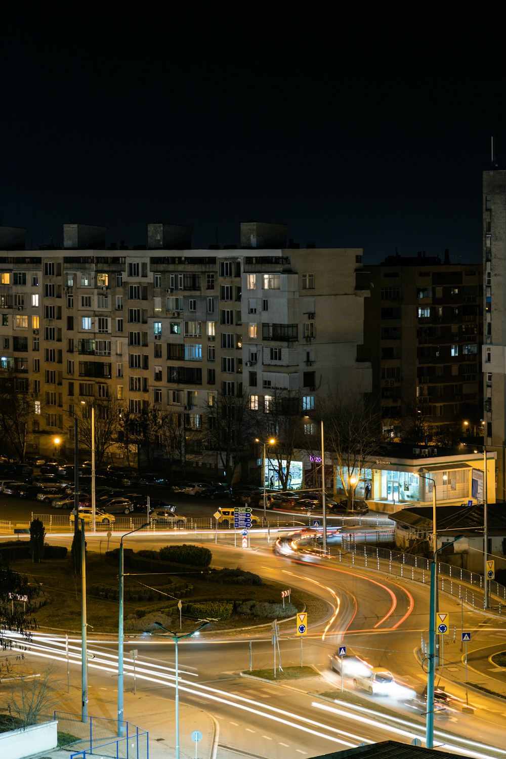 time lapse photography of cars on road near high rise building during night time