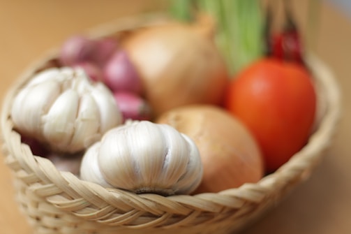 A basket filled with assorted organic vegetables and pulses.