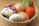 Smiling woman holding a basket of fresh organic vegetables in a bright kitchen