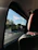 A comfortable car interior with a scenic Rajasthan highway visible through the window.