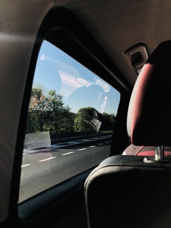 A family enjoying a road trip inside a spacious rental car with clear blue skies outside.
