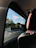 A comfortable car interior with a scenic Rajasthan highway visible through the window.