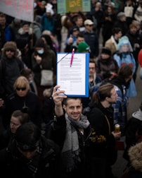 Close-up of hands signing a petition at a community engagement event.