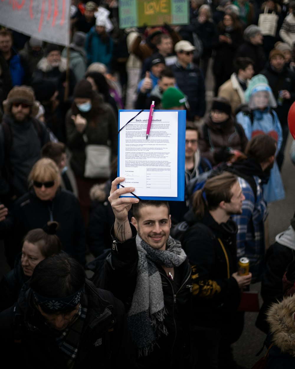 woman in black jacket holding white and green paper