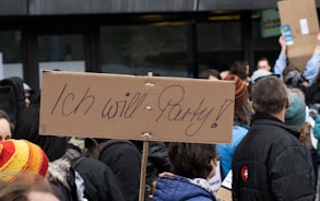 people standing and holding brown wooden board during daytime