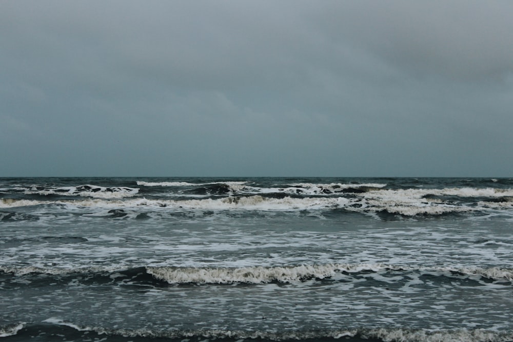 ocean waves crashing on shore during daytime