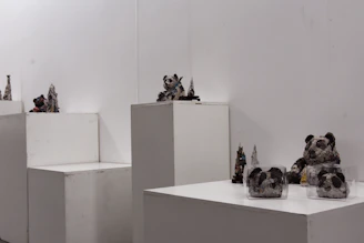 A modern sculpture made of recycled materials displayed in a minimalist gallery setting