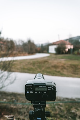 A camera on a tripod set up for a scenic outdoor shoot.