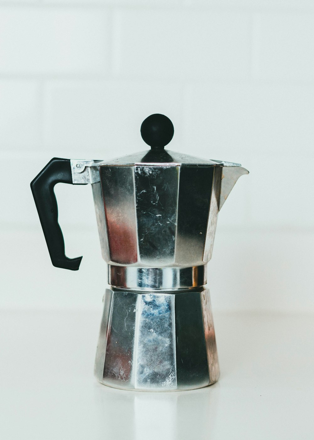 stainless steel teapot on white table