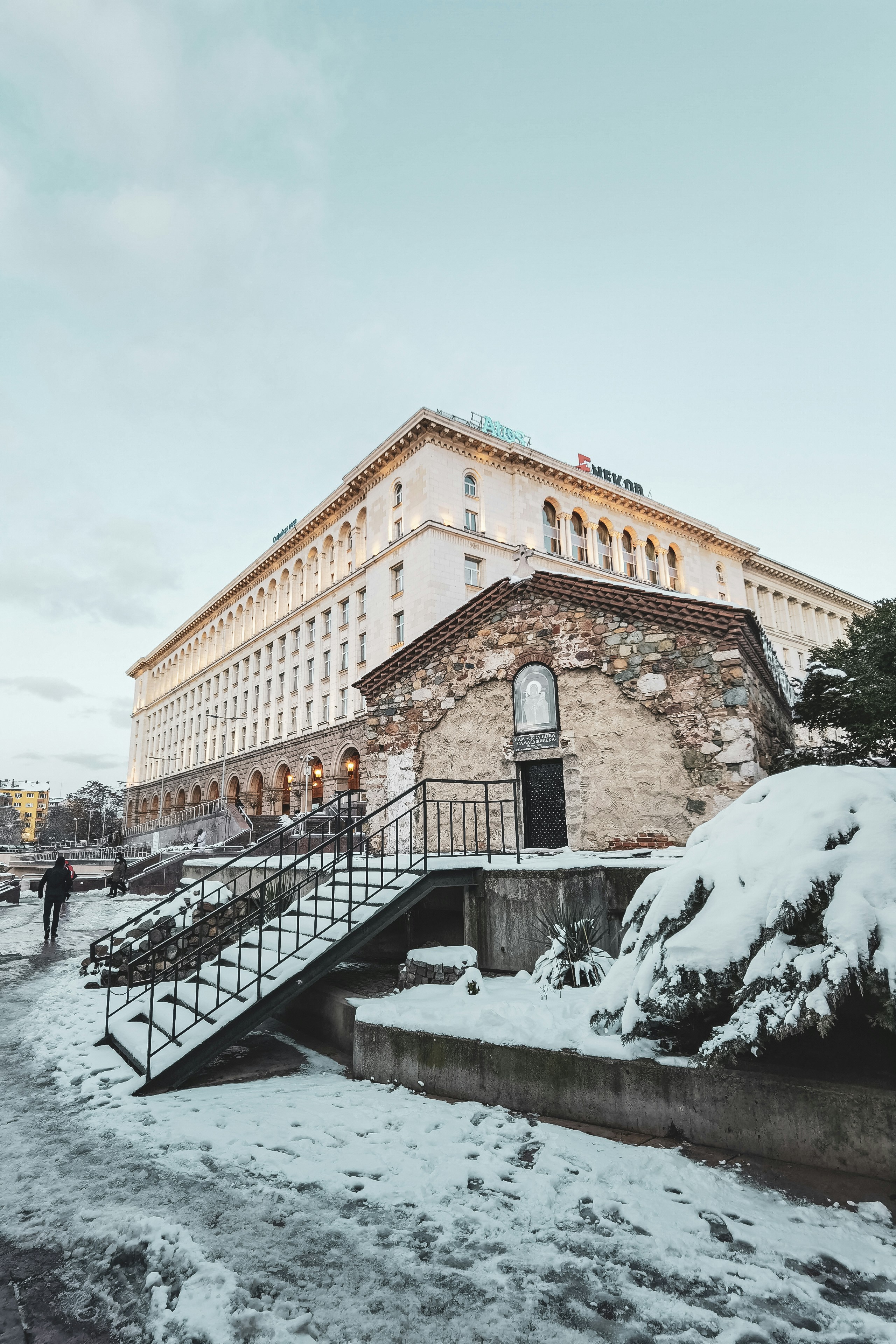 Edificio de hormigón marrón cerca de la montaña cubierta de nieve durante el día