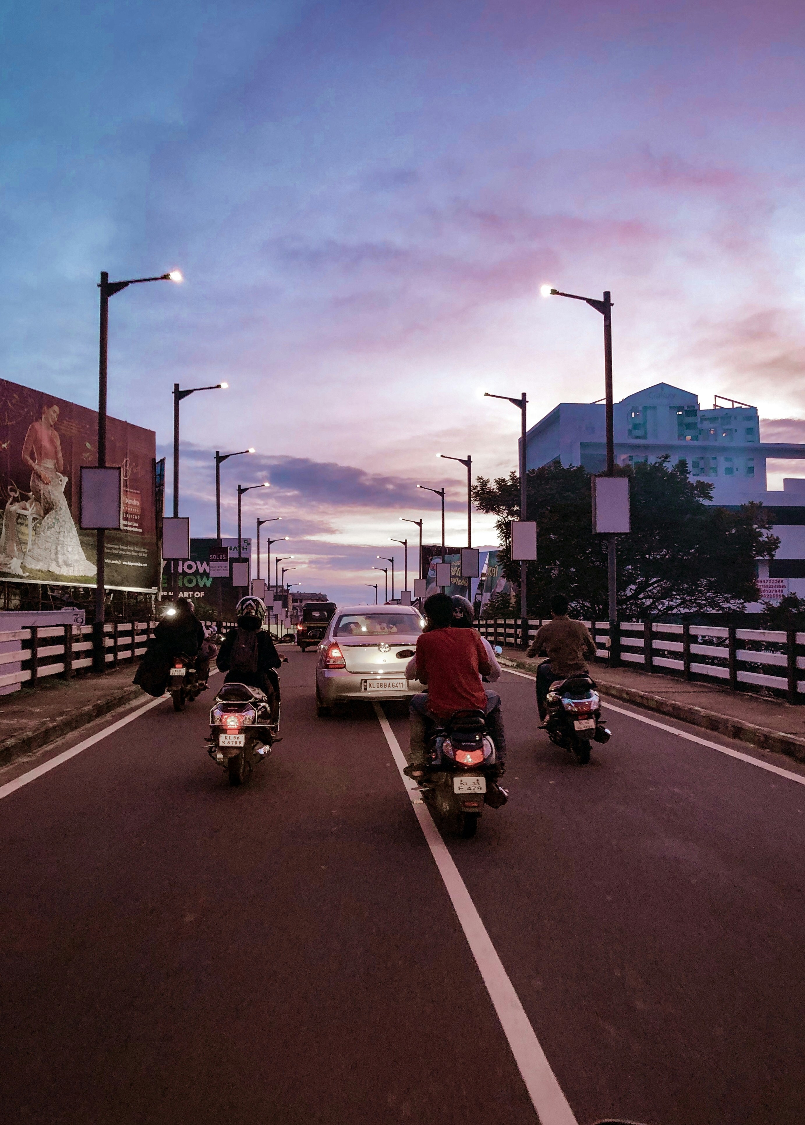 Riders on Pune-Goa highway at dusk, coastal road, dramatic sky