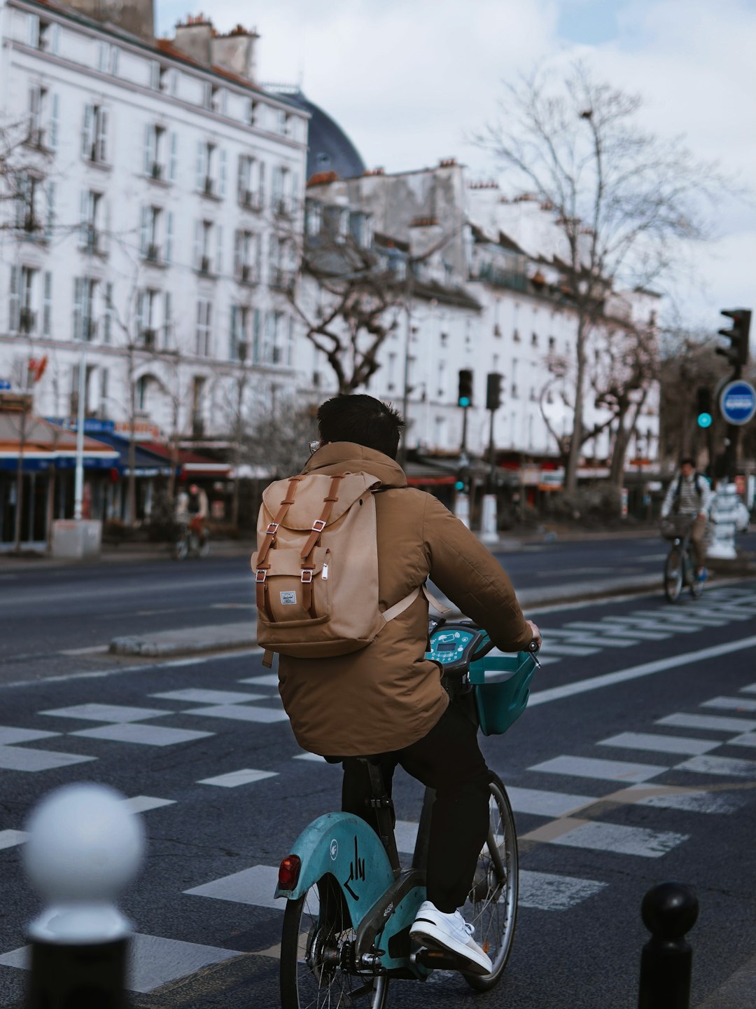 man in brown backpack riding bicycle on road during daytime