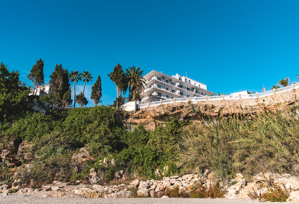 white concrete building near green trees under blue sky during daytime