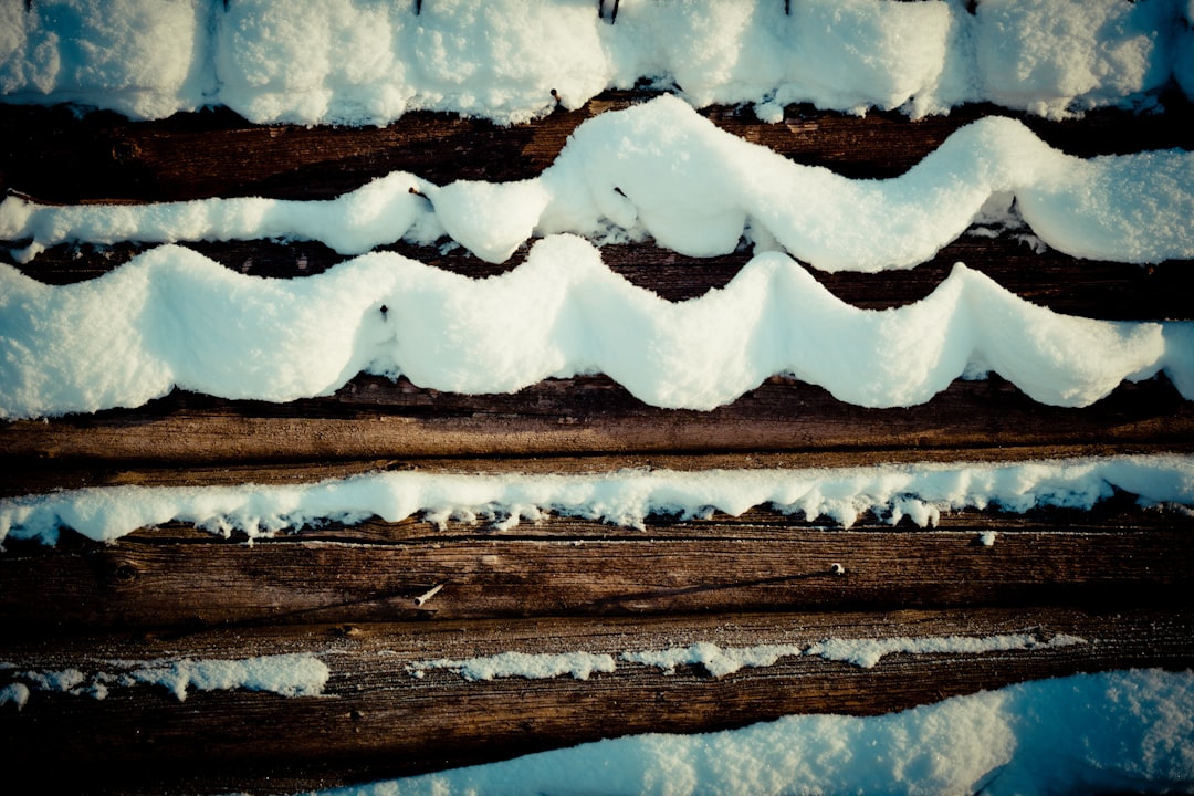 white snow on brown wooden surface