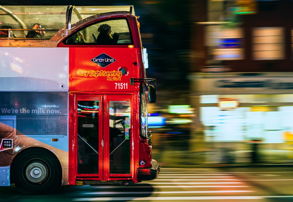 Autobús rojo y blanco en la carretera durante la noche