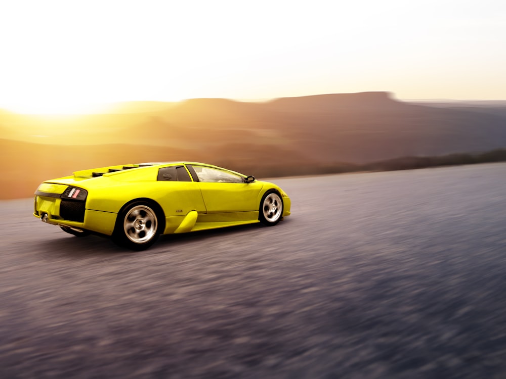 yellow coupe on gray sand during daytime