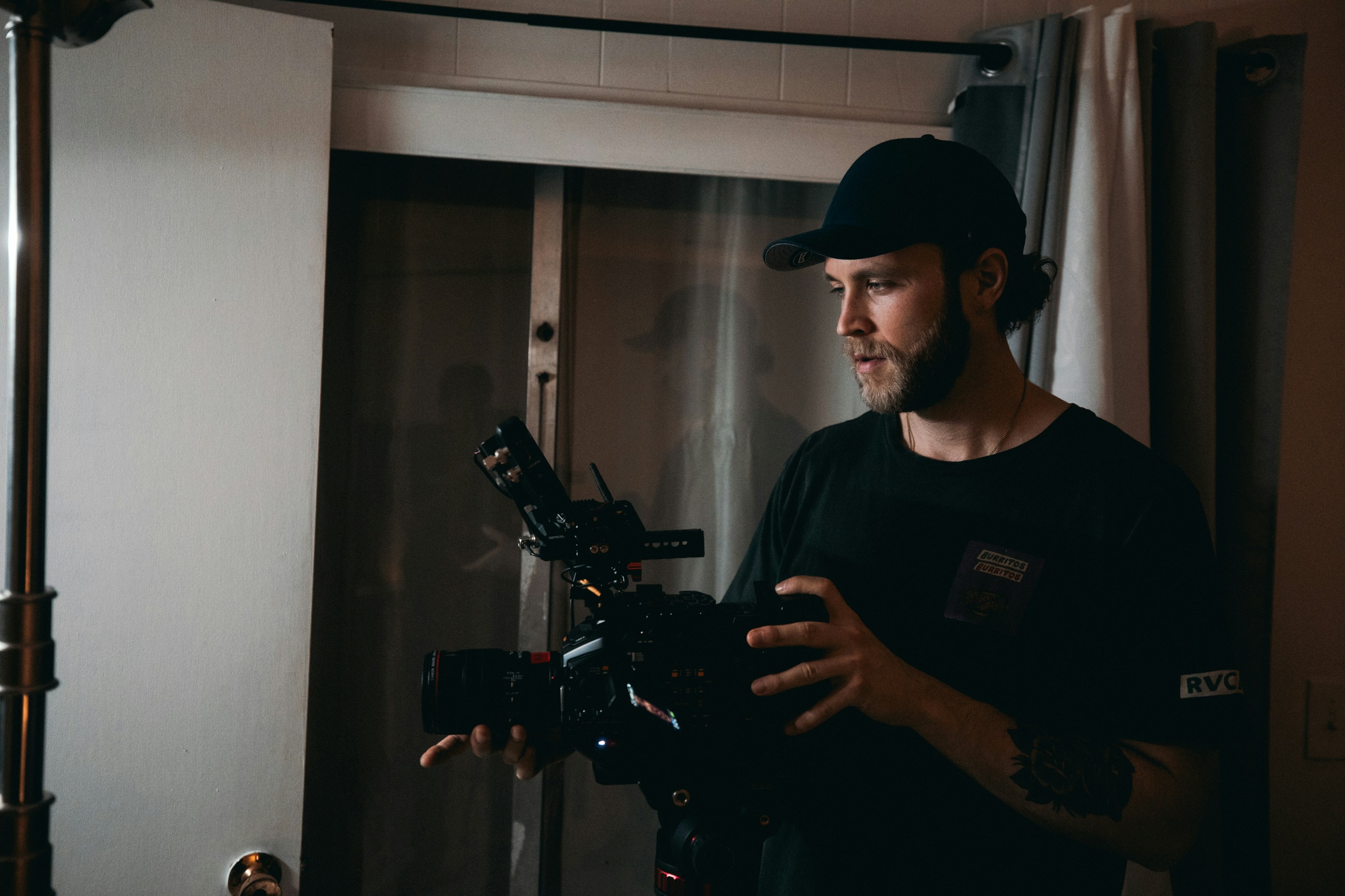 man in black crew neck t-shirt holding black video camera