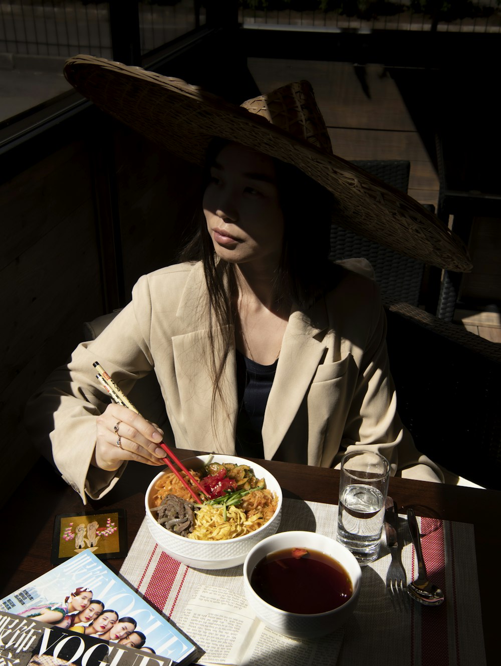 woman in white blazer holding chopsticks