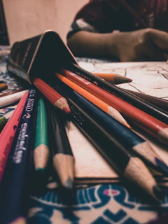 A close-up of vibrant colored pencils scattered around an open colornest coloring book.