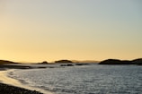 A serene coastal landscape with gentle waves and a sunset.