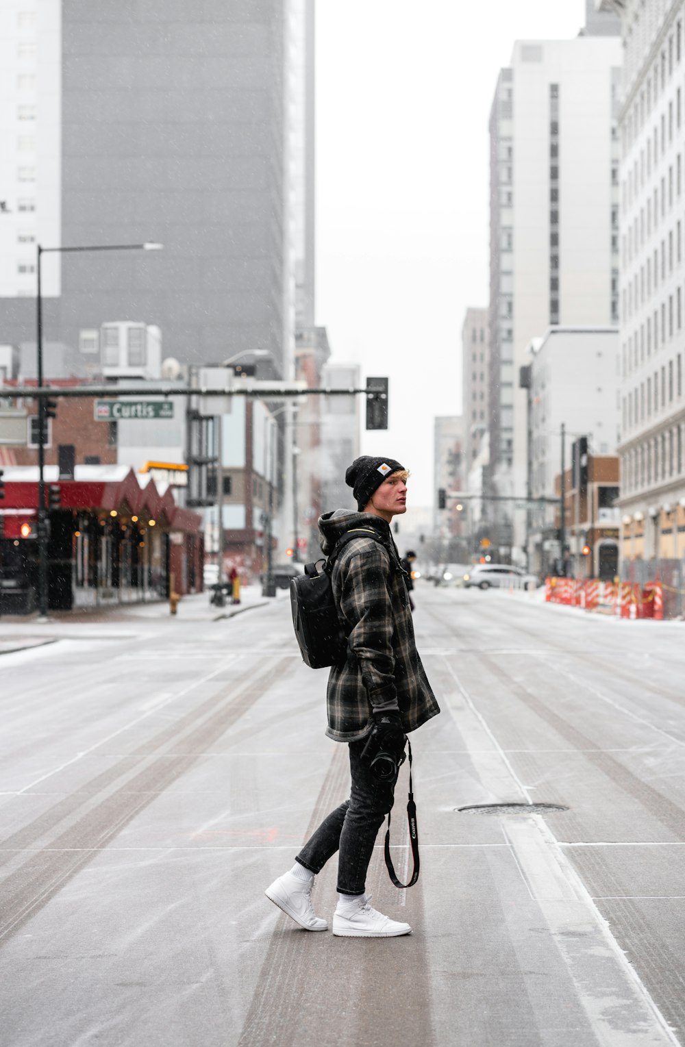 man in black leather jacket and black pants standing on road during daytime