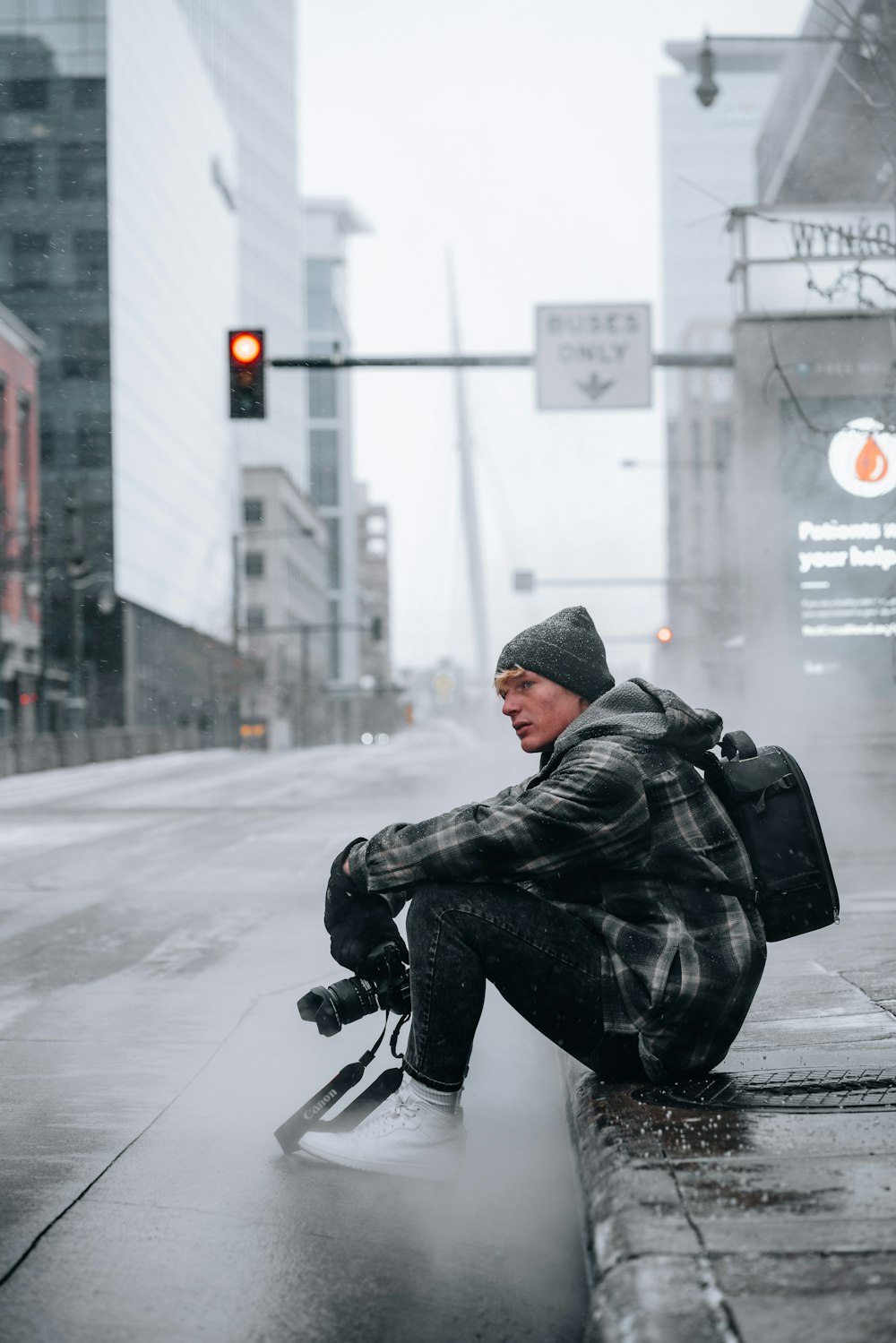 man in black leather jacket and black pants sitting on gray concrete floor