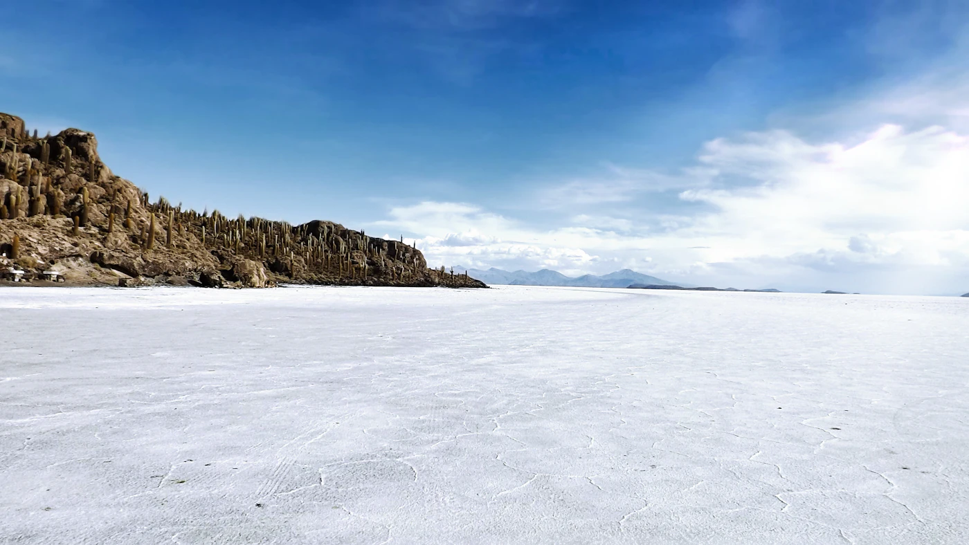 Die weisse Salzfläche des Salar de Uyuni unter blauem Himmel