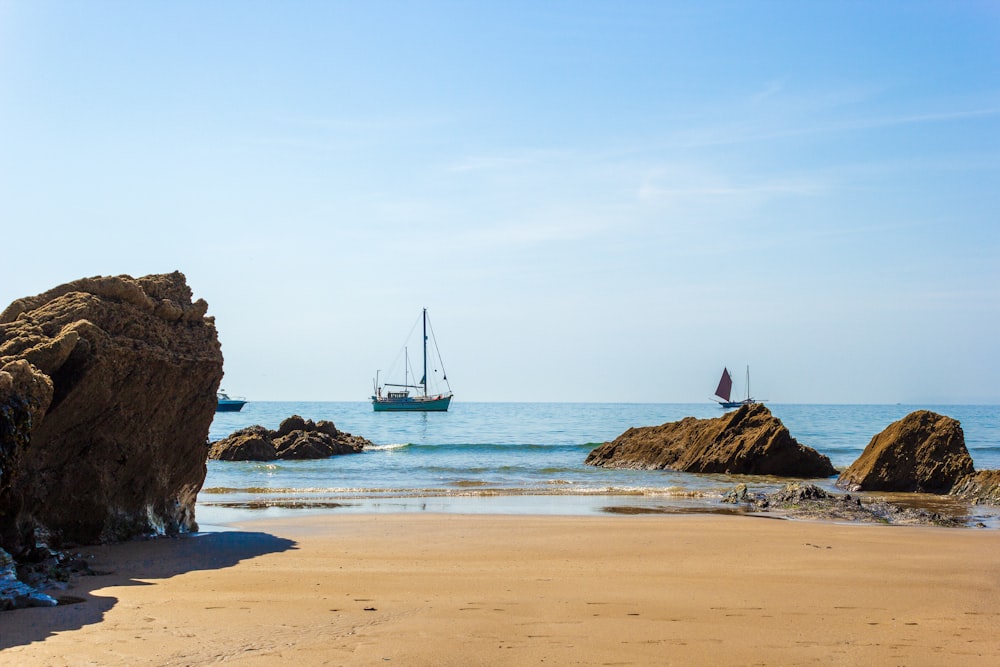 sailboat on sea shore during daytime