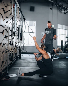 woman in black tank top and black leggings doing yoga