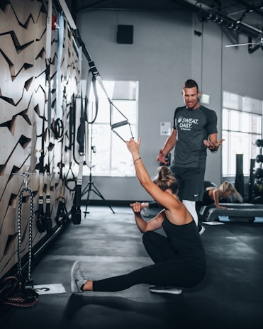 Close-up of a personal trainer guiding a client through a stretching exercise at Vyra Fitness.