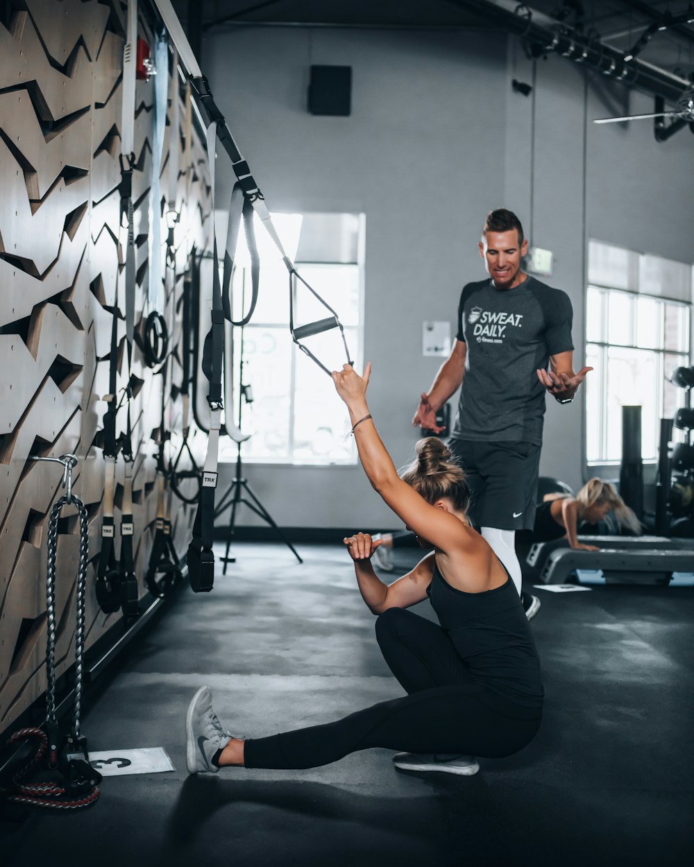 Frau in schwarzem Tanktop und schwarzen Leggings beim Yoga