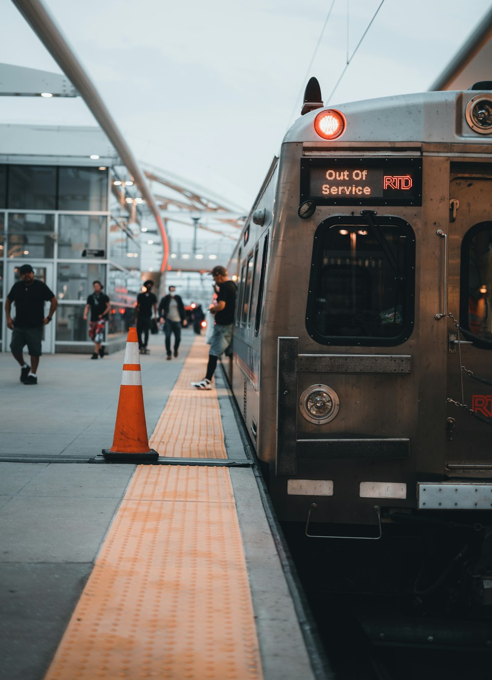 people walking on sidewalk near train during daytime