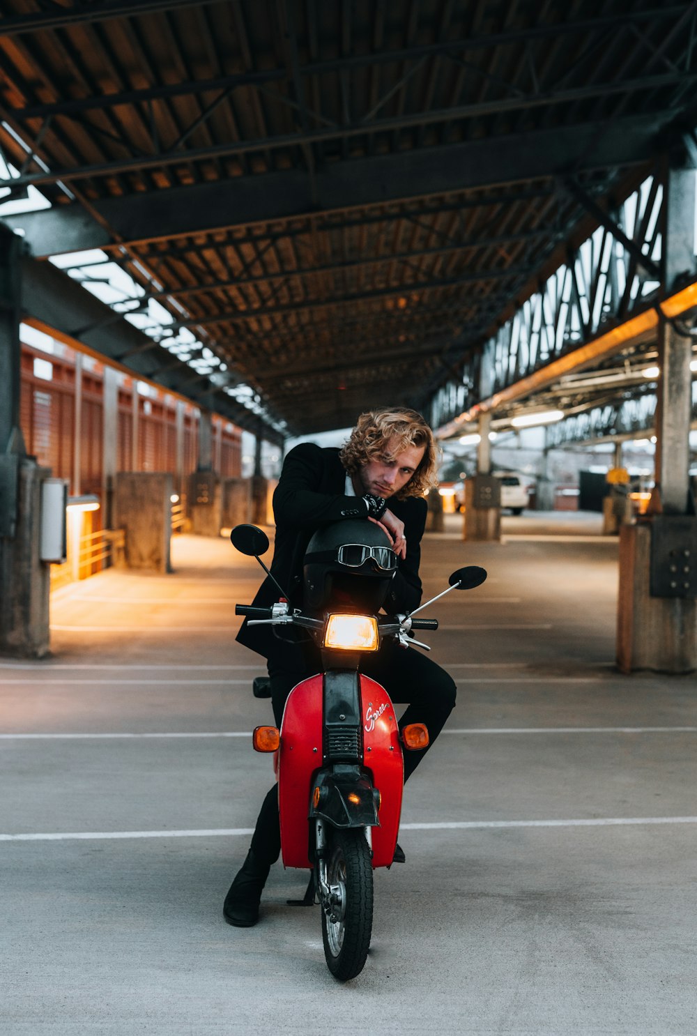 Mann in schwarzer Jacke fährt tagsüber auf rotem Motorrad auf der Straße