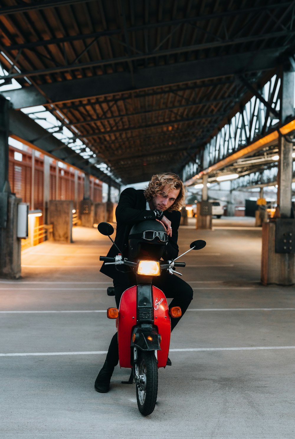 man in black jacket riding red motorcycle on road during daytime