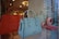 A display of luxury handbags is showcased in a window, featuring vibrant orange, blue, and green tones. The bags have elegant designs, with some resembling confectionery items. The background reflects the interior of a well-lit store with decorative lighting.