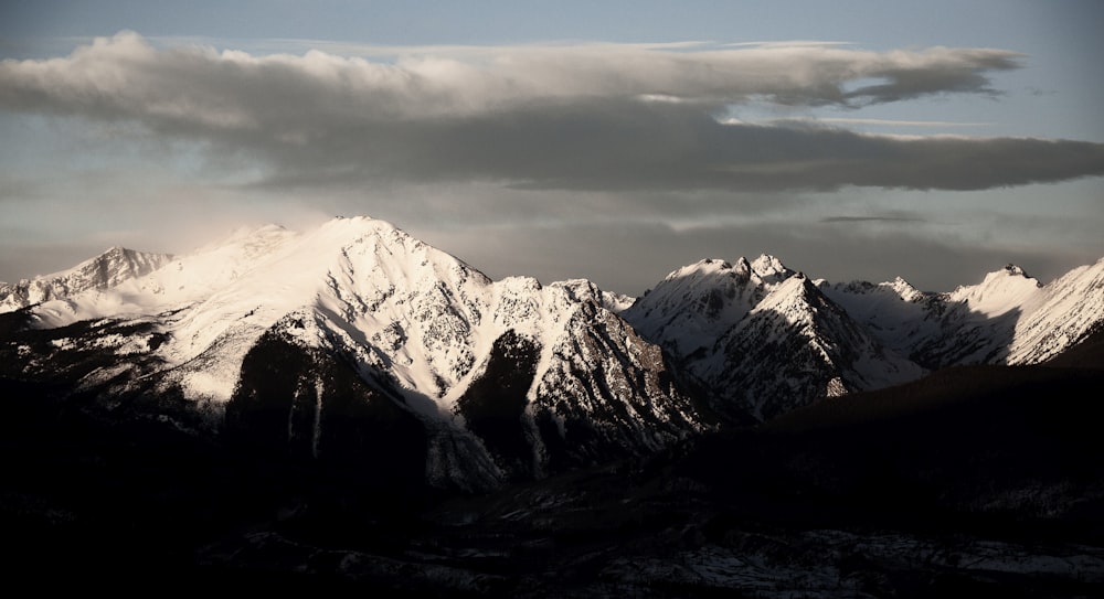 snow covered mountain under cloudy sky during daytime