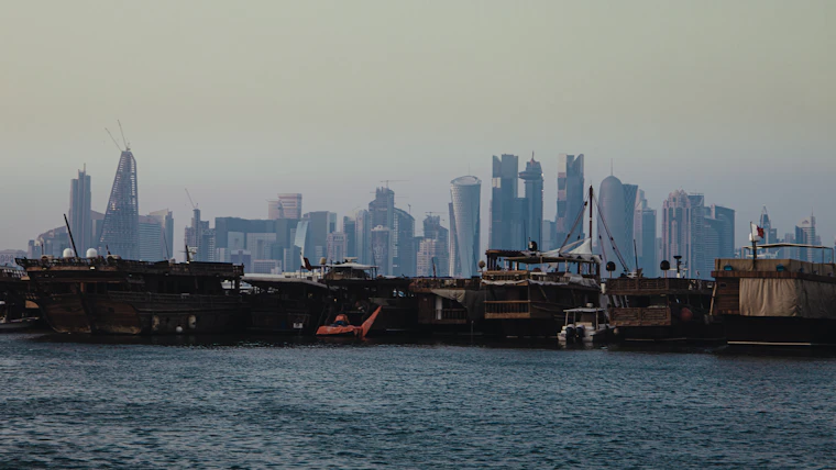Traditional wooden dhow boats moored along the Doha waterfront in Qatar