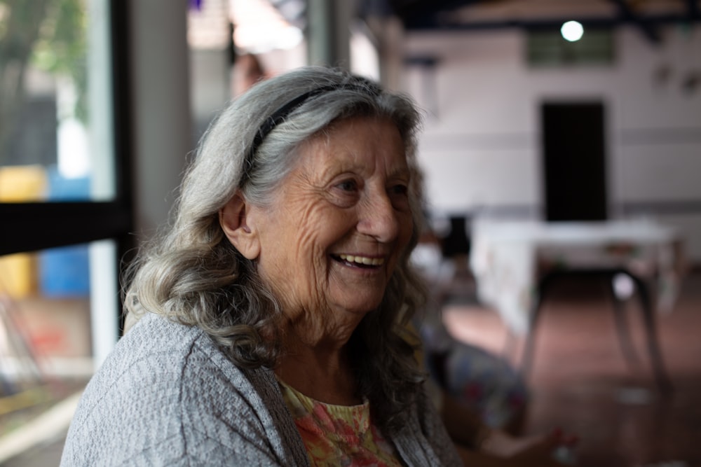 smiling woman in gray cardigan