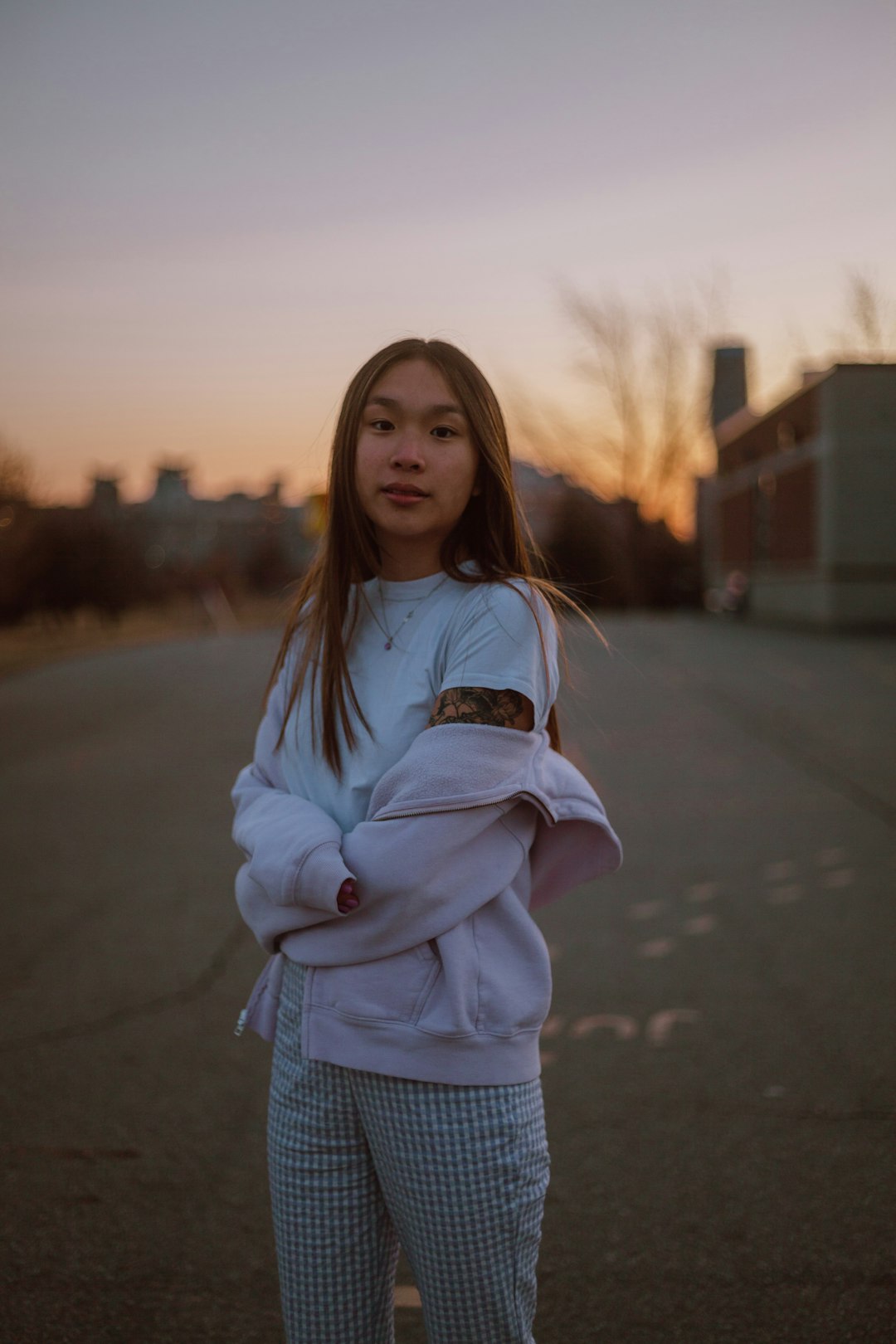 woman in white jacket standing on road during daytime