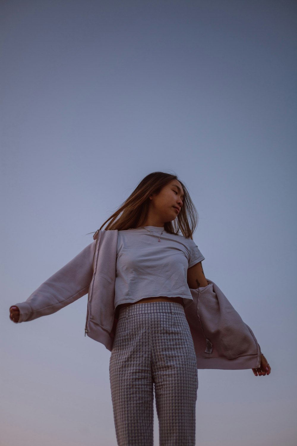 woman in white long sleeve shirt and brown and white plaid skirt