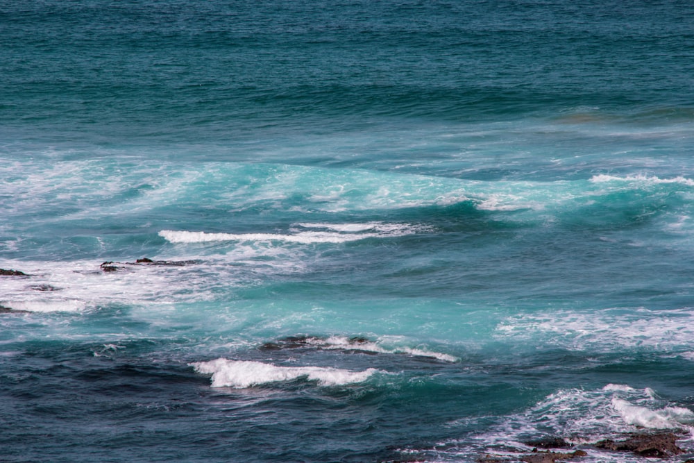 ocean waves crashing on shore during daytime