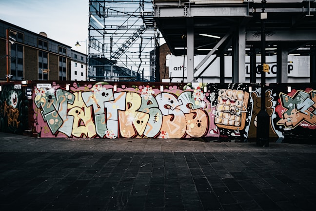 A vibrant mural in progress on an industrial site showcasing bold reds and greens.