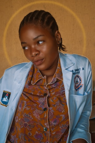 Portrait of Dr. Ana Luiza smiling gently, dressed in a white coat with a soft background.